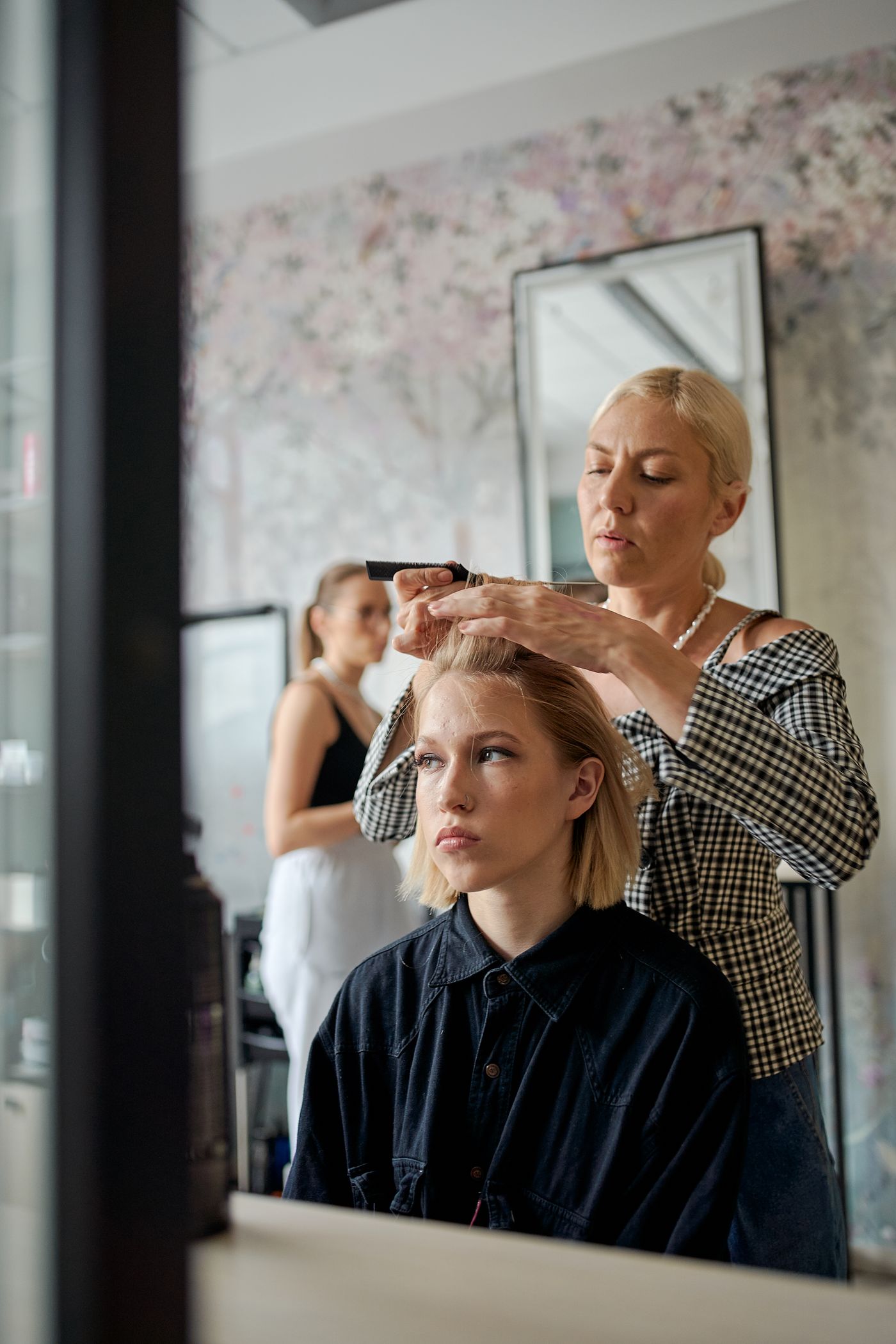 A Velina stylist sectioning a guest's hair in front of the mirror