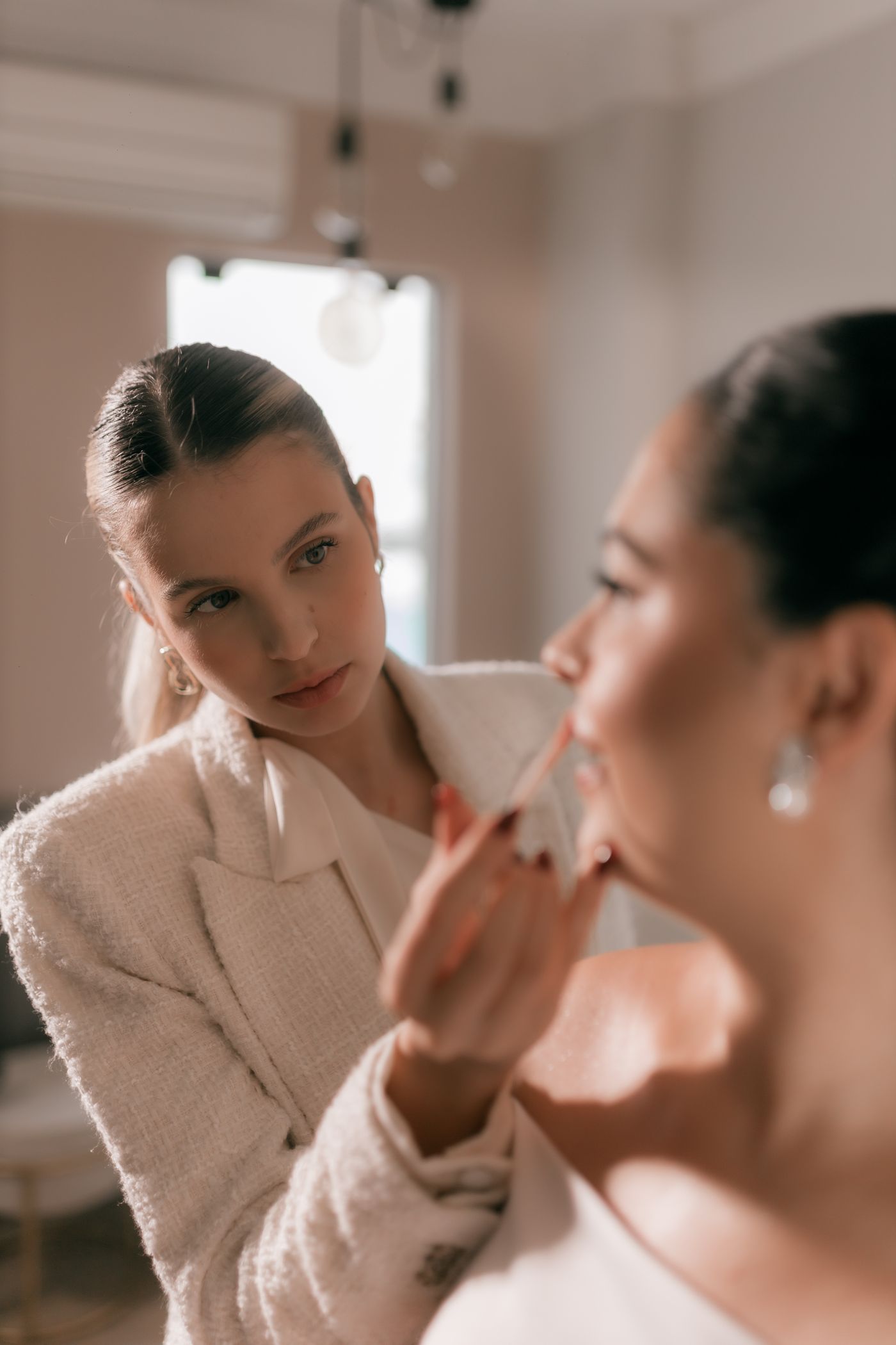 Makeup artist applying the finishing touch to a bride's lips